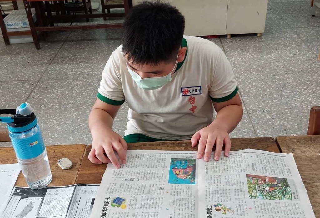 學生認真閱讀報紙，並且了解文章內容。（圖片1）