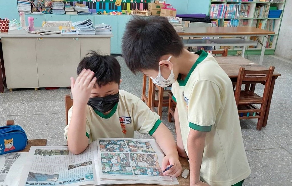 兩個學生認真看著漫畫版中的趣味校園生活故事。（圖片4）