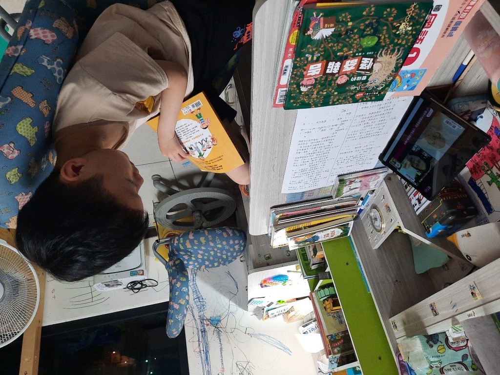 小翔拿了君偉上小學系列來閱讀，看到王淑芬老師好開心！（圖片1）