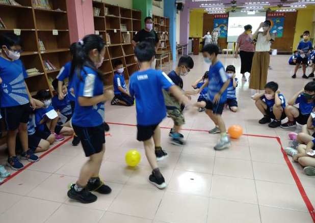 學生在方框內認真踩著彼此的氣球（圖片1）