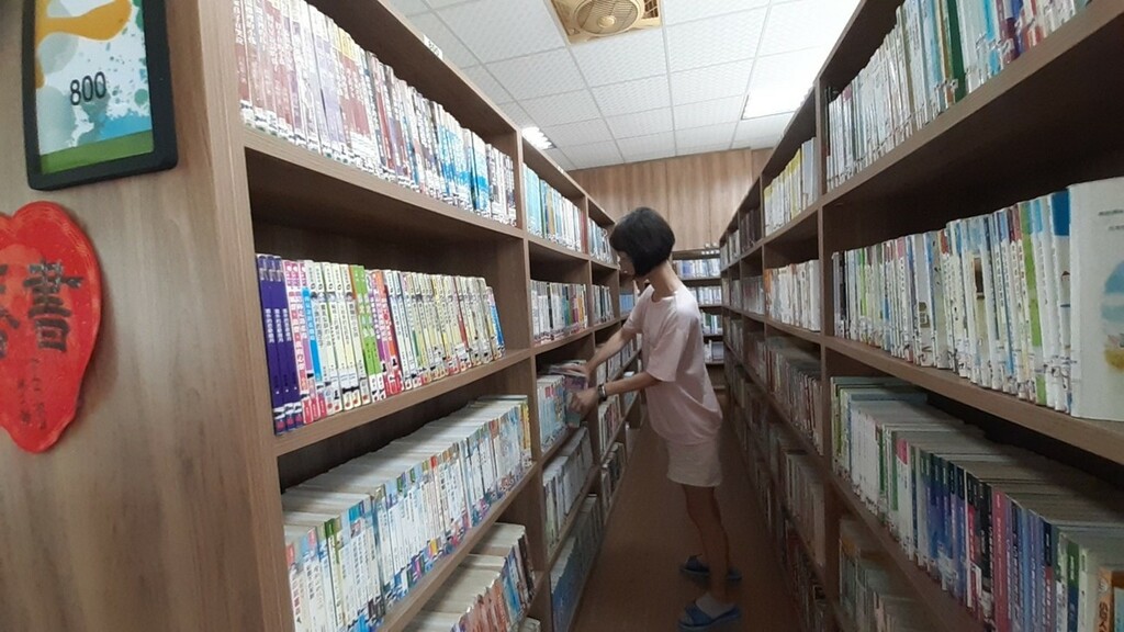 志工整理架上圖書（圖片2）