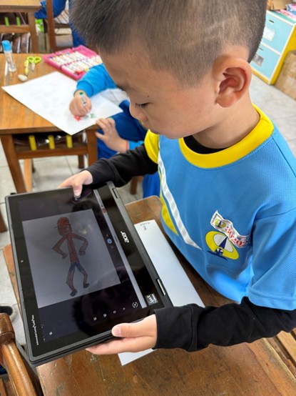 學生正利用平板電腦拍攝自己完成的圖畫人物（圖片1）