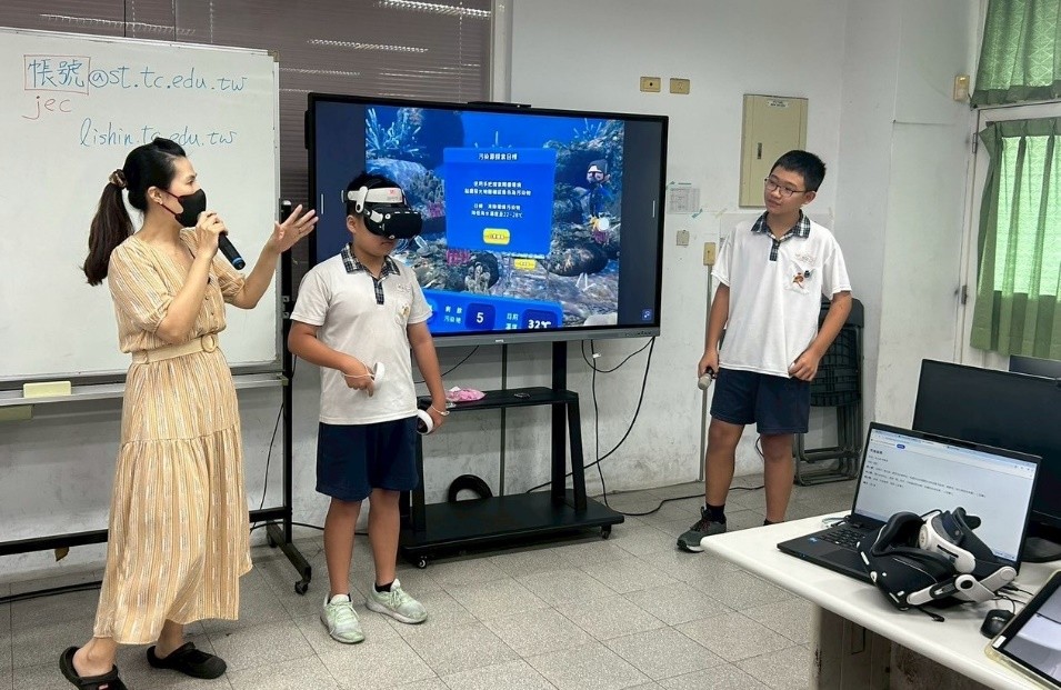 VR教材結合高年級自然課,讓小組學生共同上台發表,一人戴上VR頭盔操作,另一人透過大屏解說。(圖片2)