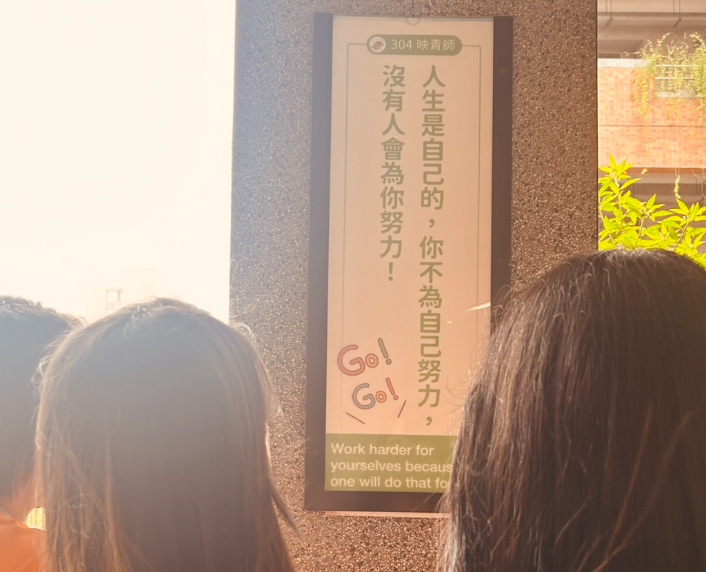 走廊牆上張貼導師鼓勵的雙語標語（圖片2）
